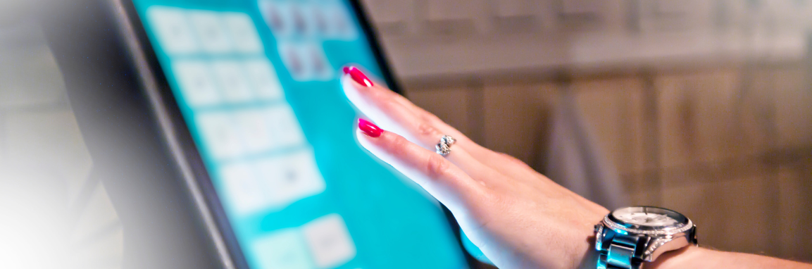 Point of sale terminal with a woman's hand with red nail polish using the touch screen.